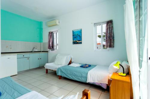 a room with two beds and a table and a kitchen at Melissa Gold Coast in Psakoudia