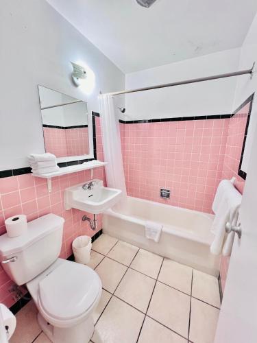 a pink bathroom with a toilet and a sink at Persepolis Inn in Niagara Falls