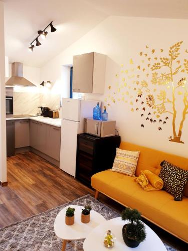 un salon avec un canapé jaune et une cuisine dans l'établissement 1 Liberte - TRIPLEX, à Saint-Affrique