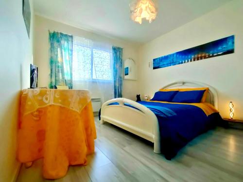 - une chambre avec un lit bleu et orange dans l'établissement BRETAGNE Chambre sur la Côte d'Émeraude Saint-Malo, à Saint-Guinoux