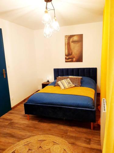 - une chambre avec un lit bleu et jaune dans l'établissement 1 Liberte - TRIPLEX, à Saint-Affrique