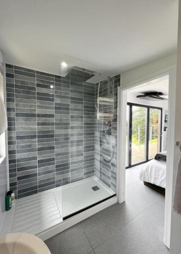 a bathroom with a shower with a glass door at The Larch in Hensol