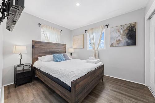 Un dormitorio con una cama grande y dos ventanas. en Charming Gem in LH, High Speed WiFi Minutes from Beach, Downtown & Petco Park!, en San Diego