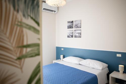 a bed with a blue headboard and white pillows at Il Confine Azzurro in Porto SantʼElpidio