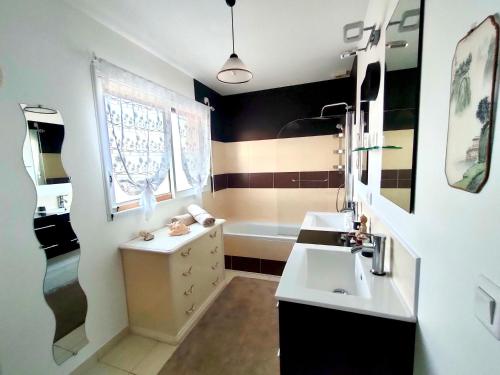 une salle de bain avec deux lavabos et une baignoire dans l'établissement BRETAGNE Chambre sur la Côte d'Émeraude Saint-Malo, à Saint-Guinoux