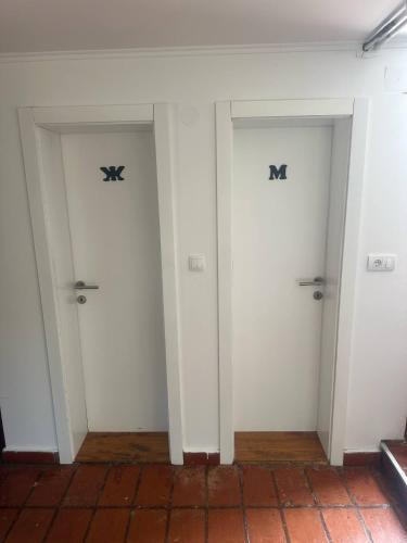 two doors with the letter m on them in a room at Apartmani Jovanovic Mala Reka BB in Bajina Bašta