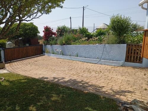 a backyard with a fence and a brick driveway at Varanda de Coimbra in Penacova