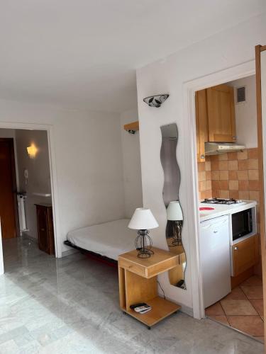 Cette petite chambre comprend un lit et une table avec une lampe. dans l'établissement Studio center - close to beaches, à Antibes
