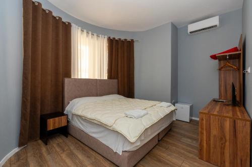 a bedroom with a bed and a television in it at Gjuhadoli Hotel 2 in Shkodër