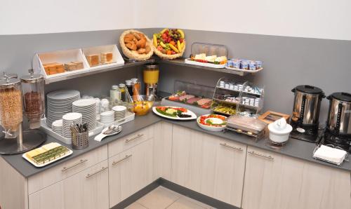 eine Küche mit Teller mit Lebensmitteln auf der Theke in der Unterkunft Hotel Apadana Frankfurt in Frankfurt am Main