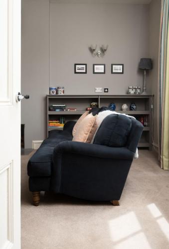 a blue couch in a living room with a table at Cambridge House in Holy Island
