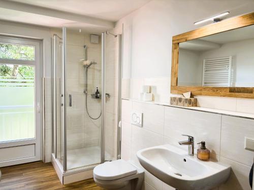 ein weißes Badezimmer mit Dusche und Waschbecken in der Unterkunft Apartment-Haus Landeskrone in Dresden