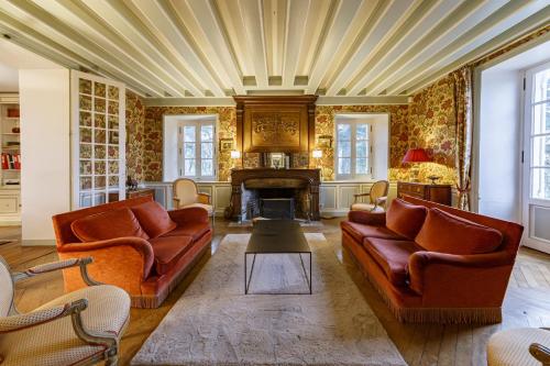 a living room with two couches and a fireplace at Le Pasty - Piscine - Tennis - Puy du Fou in Saint-Aubin-de-Luigné