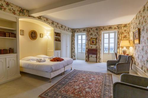 une chambre avec un lit et une chaise dans l'établissement Le Pasty Piscine Tennis Puy du Fou, à Saint-Aubin-de-Luigné
