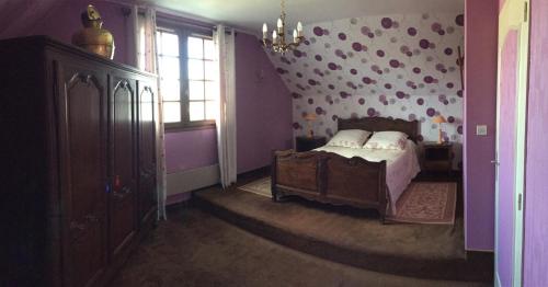 a bedroom with a bed with a polka dot wall at Le bon séjour in Saint-Hilaire-Petitville