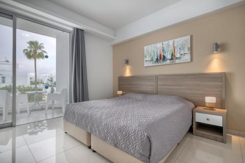 a bedroom with a large bed and a balcony at Bellini Hotel in Ayia Napa