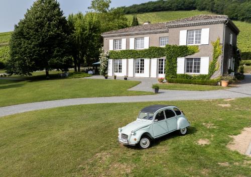 an old blue car parked in front of a house at Villa Saint-Lager - Séjour de charme au cœur du Beaujolais in Saint-Lager