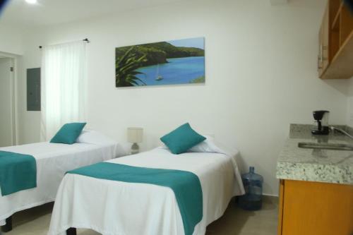 two beds in a room with a view of the ocean at Edifico con departamentos amplios cerca de la playa in Puerto Morelos