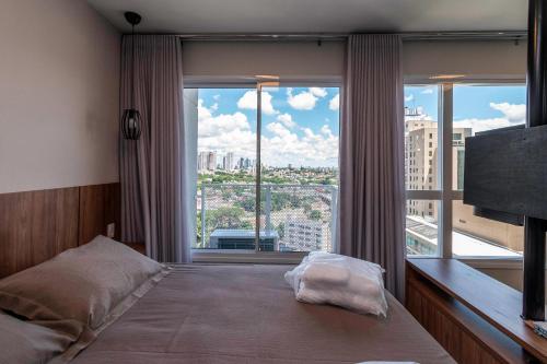 a bedroom with a bed and a large window at Metropolitan Sidney - MSS in Goiânia