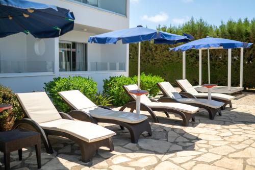 a row of chairs and umbrellas on a patio at Bellini Hotel in Ayia Napa