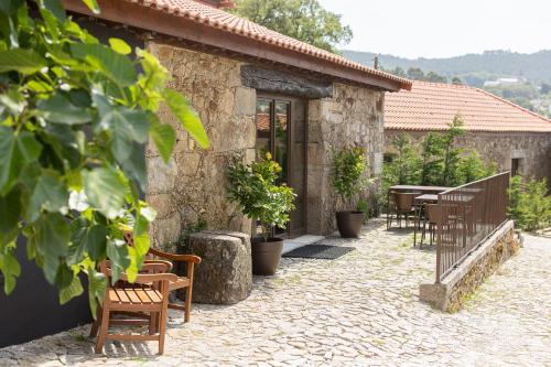 a stone building with chairs and tables and a patio at CasaNova Farmhouse in Braga