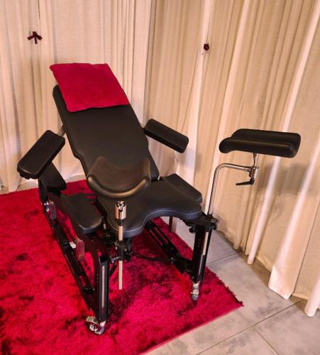 une chaise de barbier posée sur un tapis rouge au sol dans l'établissement Etoiles de Provence GLAMOUR, à La Ciotat