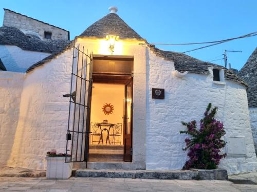 a white brick house with a door and a table at Romantic Corner in Alberobello