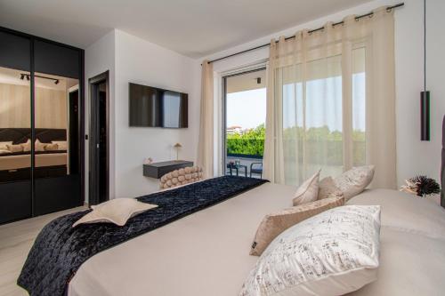 sypialnia z dużym łóżkiem i dużym oknem w obiekcie Villa Delecto Sea View Kamenjak, Premantura w mieście Premantura