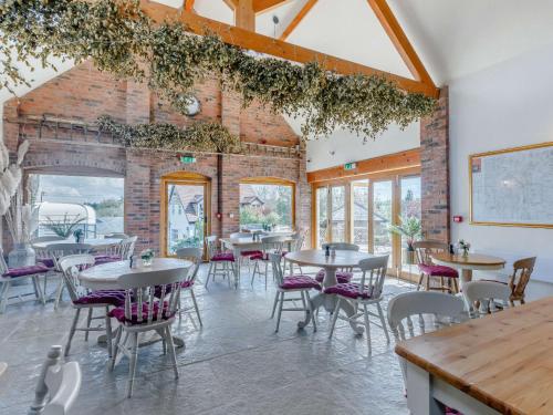 a dining room with tables and chairs and a brick wall at 2 Bed in Worcester CC008 in Clifton upon Teme