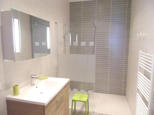 La salle de bains est pourvue d'un lavabo et d'un tabouret vert. dans l'établissement Côté Vignes à Bélesta, à Bélesta