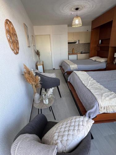 une chambre d'hôtel avec trois lits et un canapé dans l'établissement La Rose des Sables Vue à 180 degrés sur la Mer, à La Grande Motte