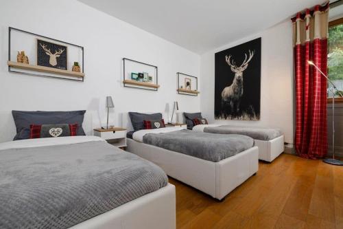 - une chambre avec 2 lits et une peinture murale sur cerfs dans l'établissement Central Chamonix - Quiet & Parking 5px Apartment, à Chamonix-Mont-Blanc