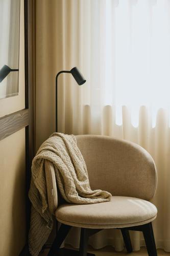 a blanket sitting on a chair next to a lamp at Raibu Ghent by StayC in Ghent