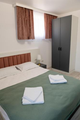 a bedroom with a bed with two towels on it at Cozy House in Piatra Neamţ