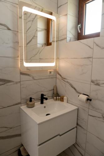 a bathroom with a white sink and a mirror at Cozy House in Piatra Neamţ