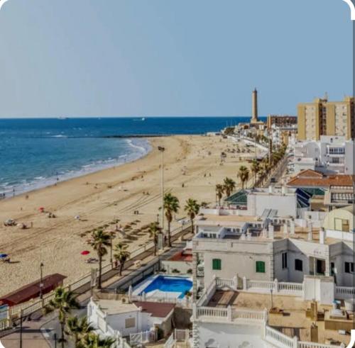 a view of a beach with buildings and the ocean at Chipiona Center in Chipiona