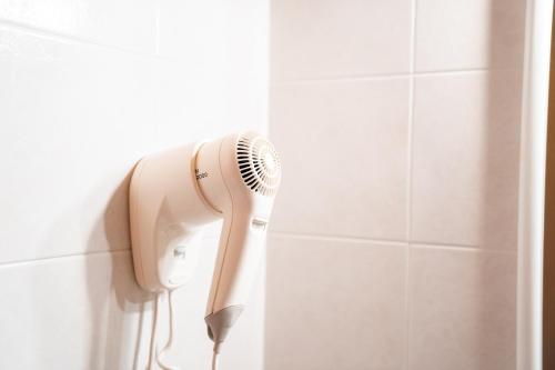 a hairdryer hanging on a wall in a bathroom at Enrosadira in Predaia