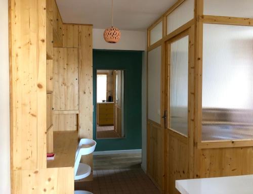 Cette chambre est dotée de murs en bois, d'une table et de chaises. dans l'établissement Appartement de charme à 250m de la plage, à Houlgate