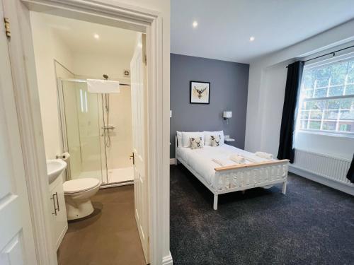a bedroom with a bed and a bathroom with a toilet at Higher Lane House in Plymouth