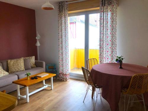 un salon avec une table et un canapé dans l'établissement Appartement de charme à 250m de la plage, à Houlgate