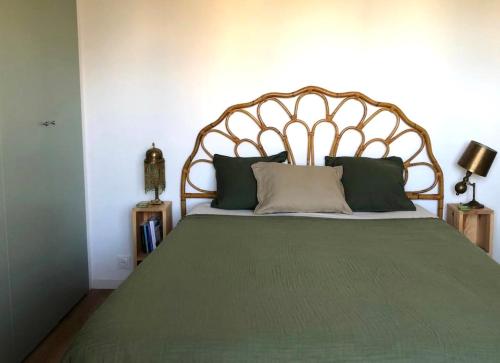 une chambre avec un grand lit avec une tête de lit en bois dans l'établissement Appartement de charme à 250m de la plage, à Houlgate