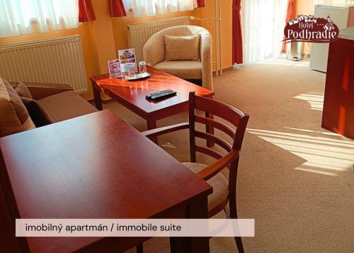 a living room with a wooden table and chairs at Hotel Podhradie in Považská Bystrica