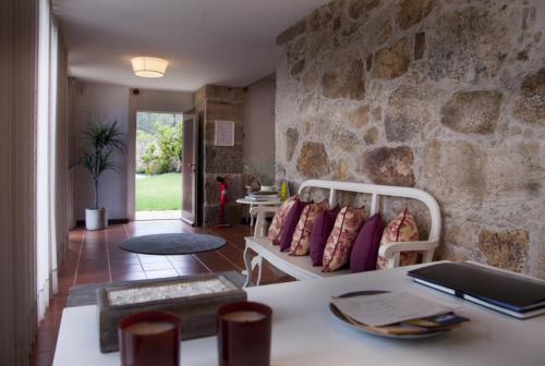 a living room with a stone wall at Quinta do Cerqueiral in Arcos de Valdevez