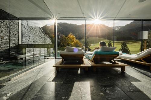 a woman sitting on a couch in a glass house at Jungbrunn Der Gutzeitort in Tannheim
