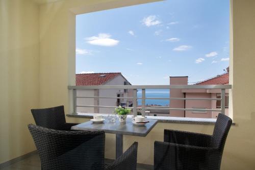 a dining room with a table and chairs and a large window at Guesthouse Aroma in Makarska