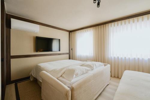 a hotel room with a bed and a television at Raibu Ghent by StayC in Ghent