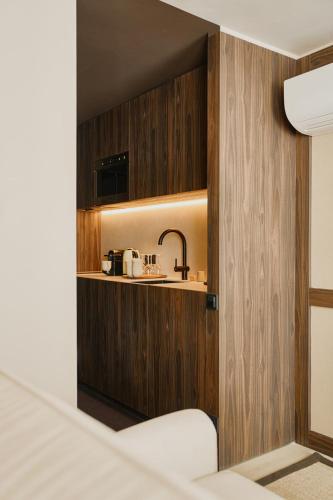 a small kitchen with wooden walls and a sink at Raibu Ghent by StayC in Ghent