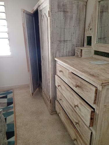 a wooden dresser in a room with a mirror at Savanna Breeze Villa in Malindi