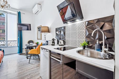 une cuisine avec un évier et un plan de travail dans l'établissement A 2 pas de la Mer - Climatisation - Wifi - Cuisine - Tramway, à Nice