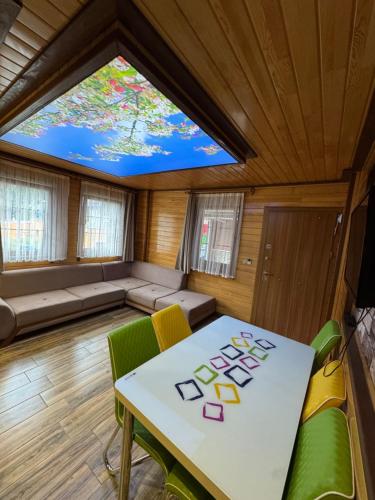 a room with a table and chairs and a large window at Fındıkoğlu Otel in Çaykara